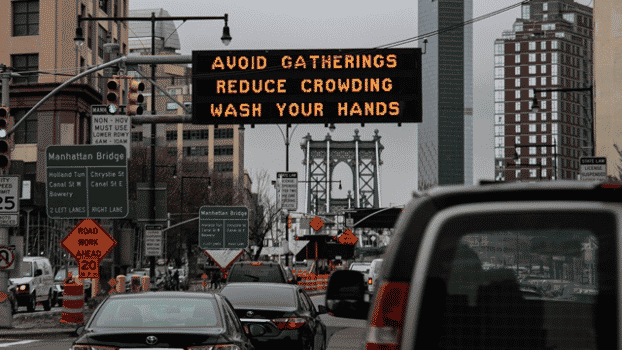 Sign in NYC saying Avoid Gatherings Reduce Crowding Wash Your Hands