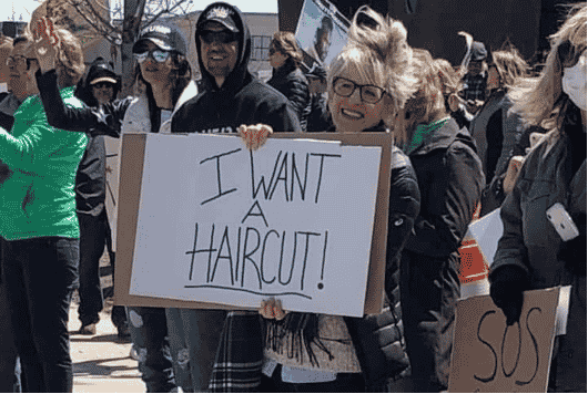 Someone holding up a sign that says I want a haircut