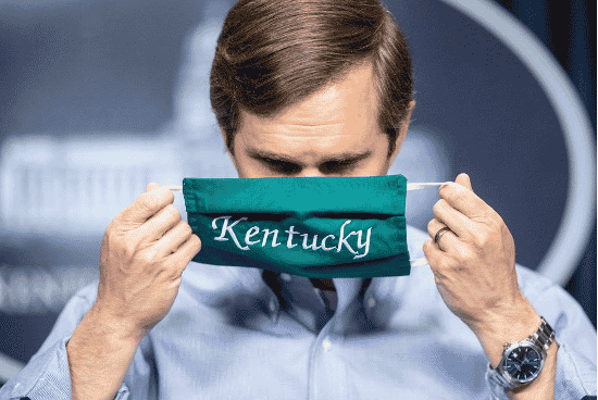 Bashear holding a mask with Kentucky written on it
