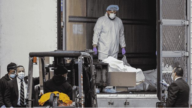 Medical staff transporting bodies on forklift